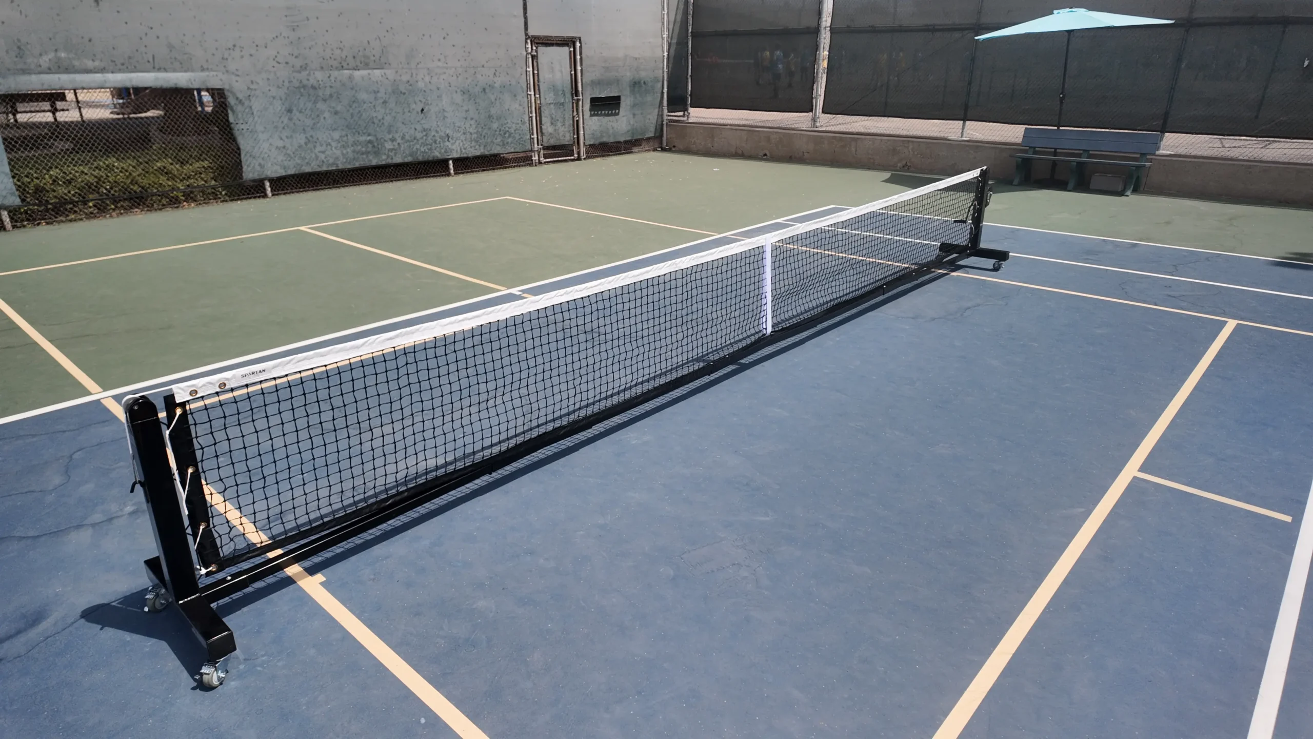 Spartan portable pickleball net on blue court overview shot