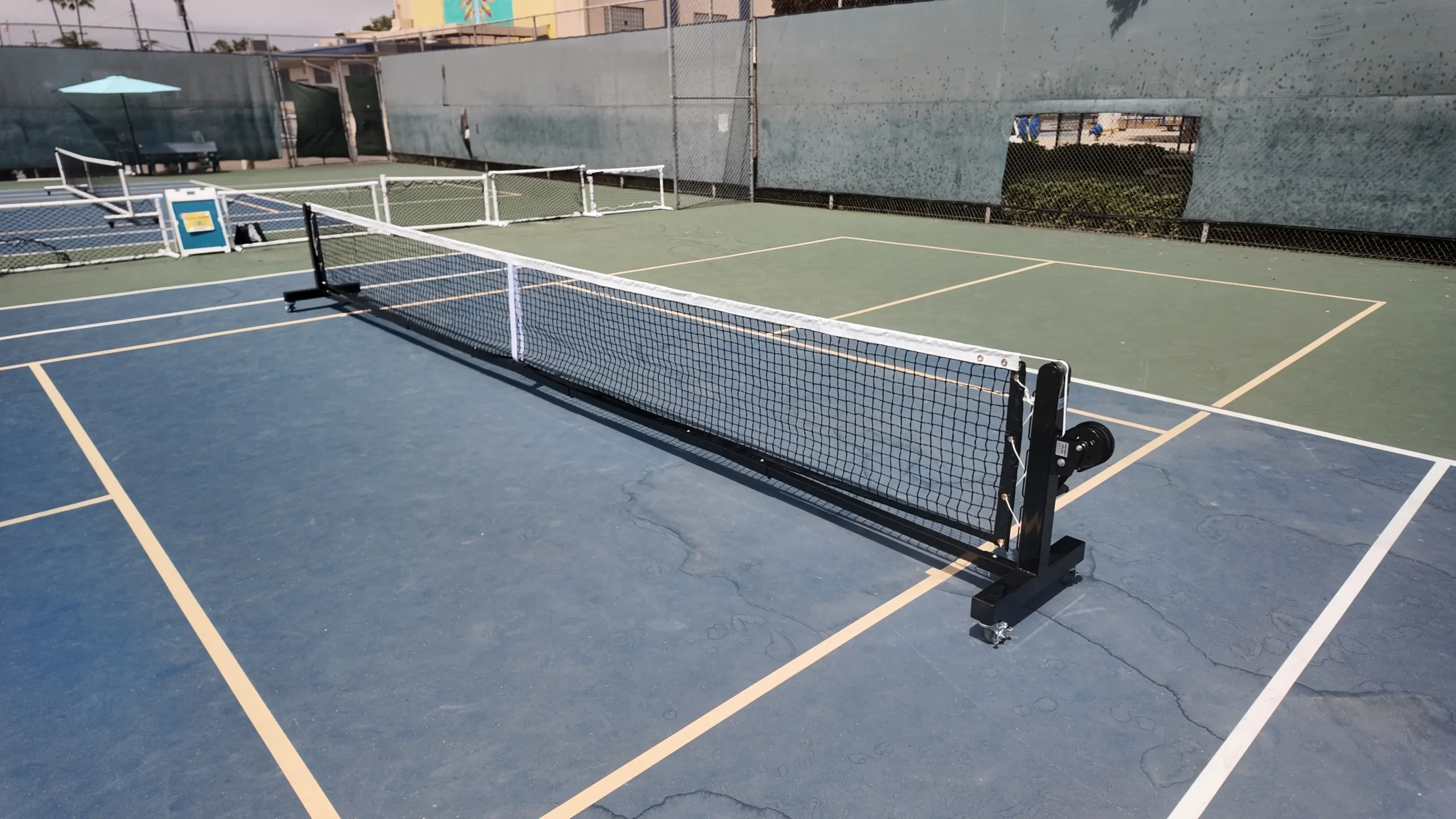 Spartan portable pickleball net on blue court side view